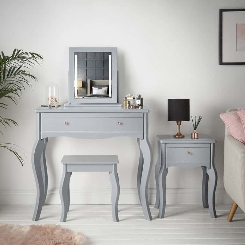 A graceful gray-colored vanity design with a small mirror, minimum storage space, and a matching stool, in a white room.