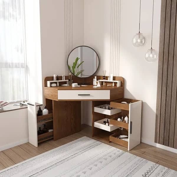 A pretty wooden corner dressing table design with a round mirror and lots of storage space, in a white room.