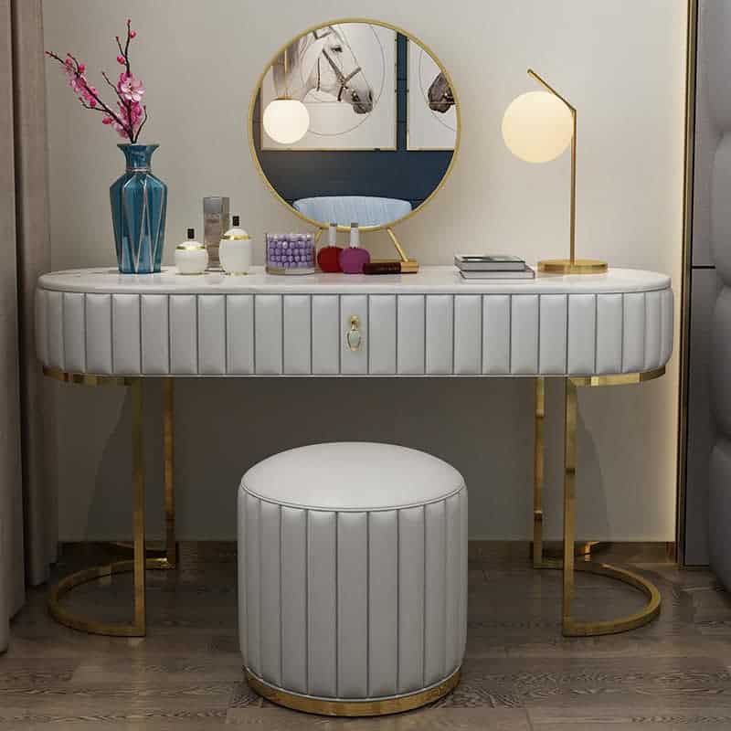 An elegant white-colored dresser with a round mirror, minimum storage space, and a matching stool, in a white room.
