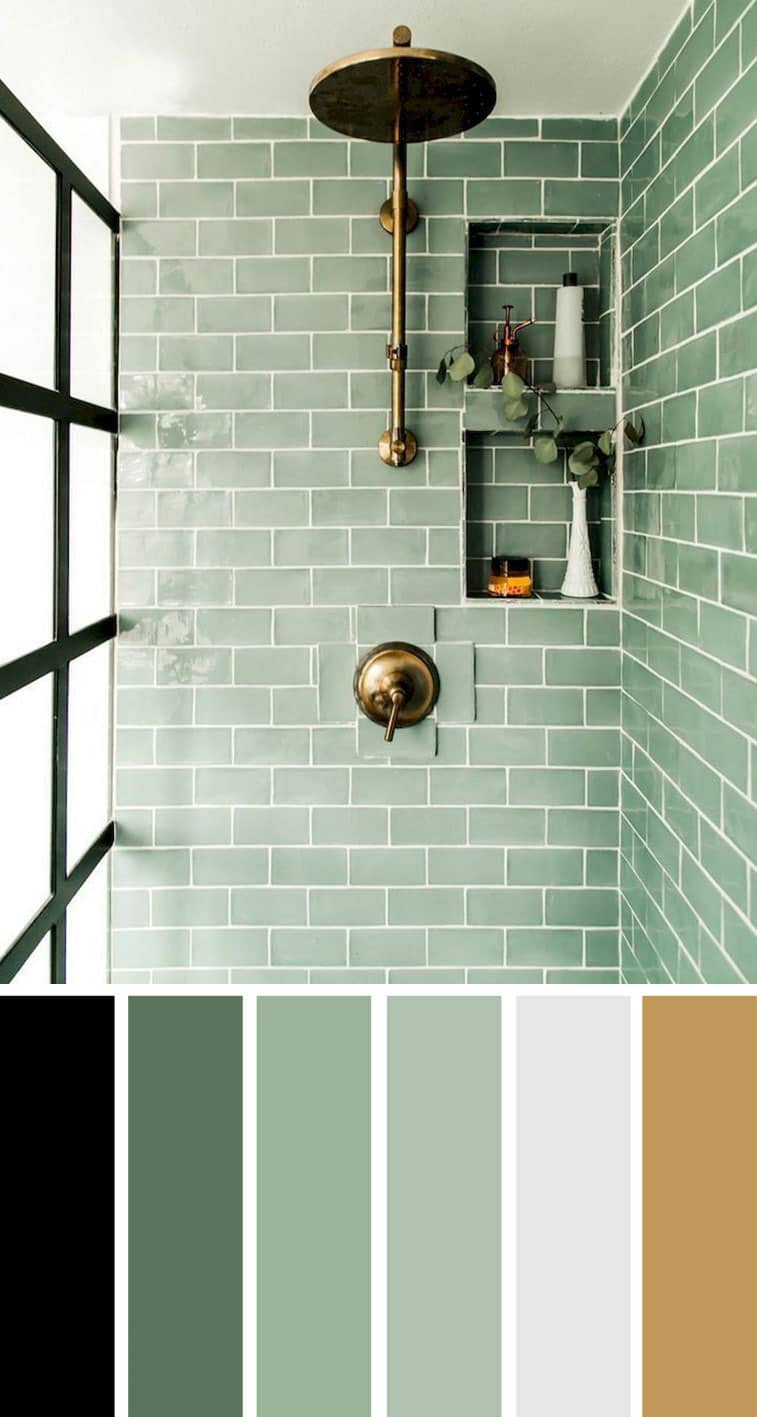 A bathroom with aqua tiles and gold shower fixtures