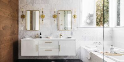 Beautiful bathroom vanity space with twin mirrors and wall mounted lighting fixtures