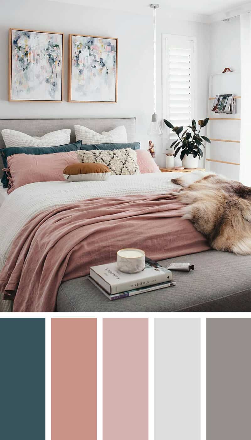 A bedroom with white walls , a light grey bed and blue and pink furnishings