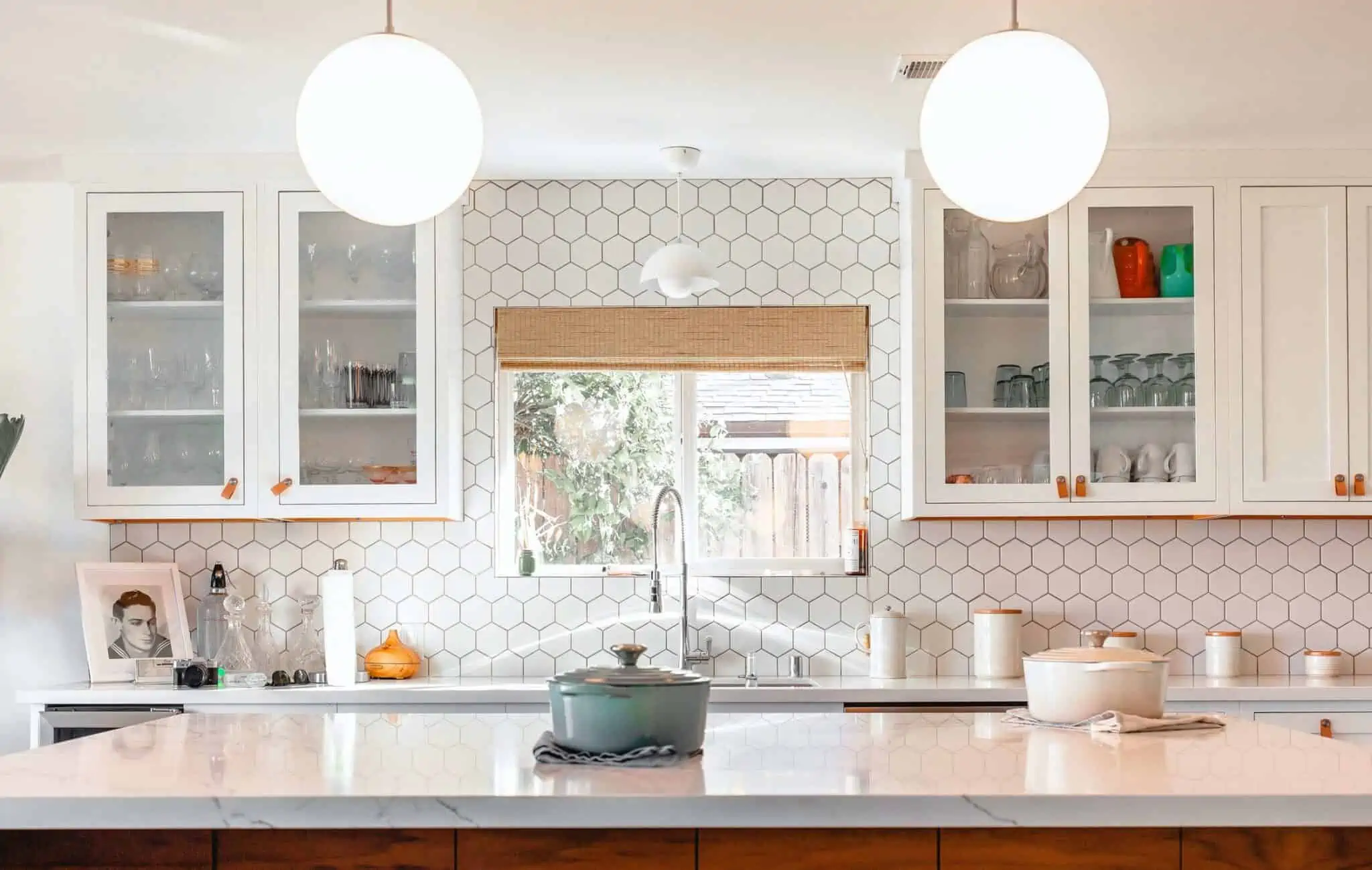 A beautiful glass-front cabinetry in a white kitchen area.