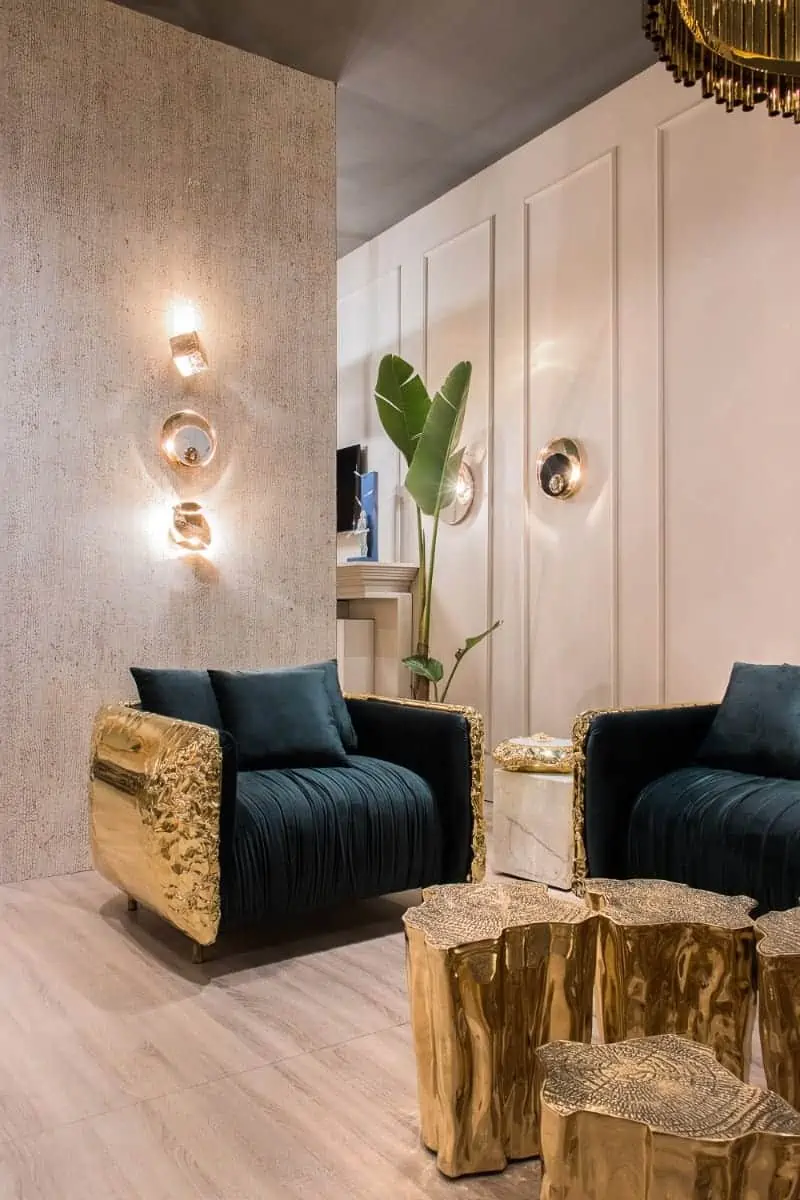 a living room with light gold wall colour, blue arm chair and gold detailing 