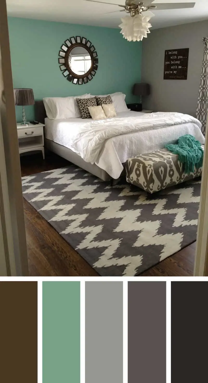 A bedroom with turquoise walls , wood flooring and grey carpet