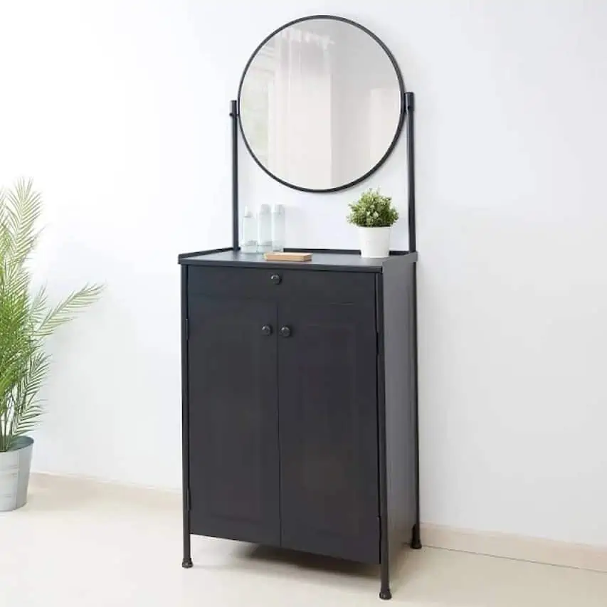 A simple black dresser with a round mirror and good storage space, in a white room.