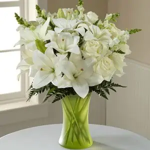 white lily flowers in a green vase