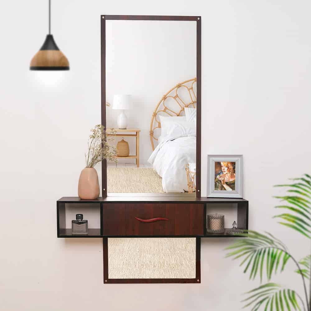 A beautiful, wooden, wall-mounted dresser with a rectangular mirror and little storage space, in a white room.