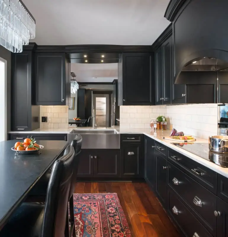 A black monochromatic kitchen cabinet in a small kitchen area.