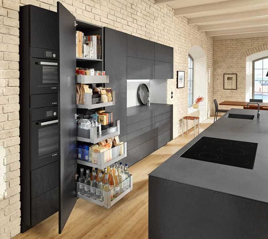 A spacious black-colored tall units of cabinetry holding lots of food supplies.