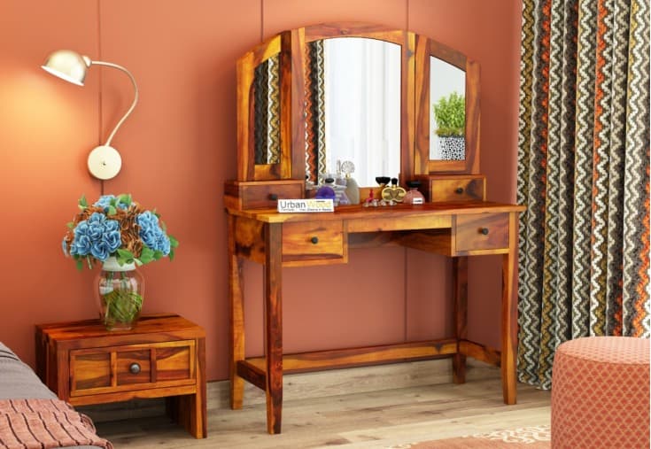 A beautiful wooden dressing table design with 3-fold mirrors and minimum storage space, in a orange bedroom.