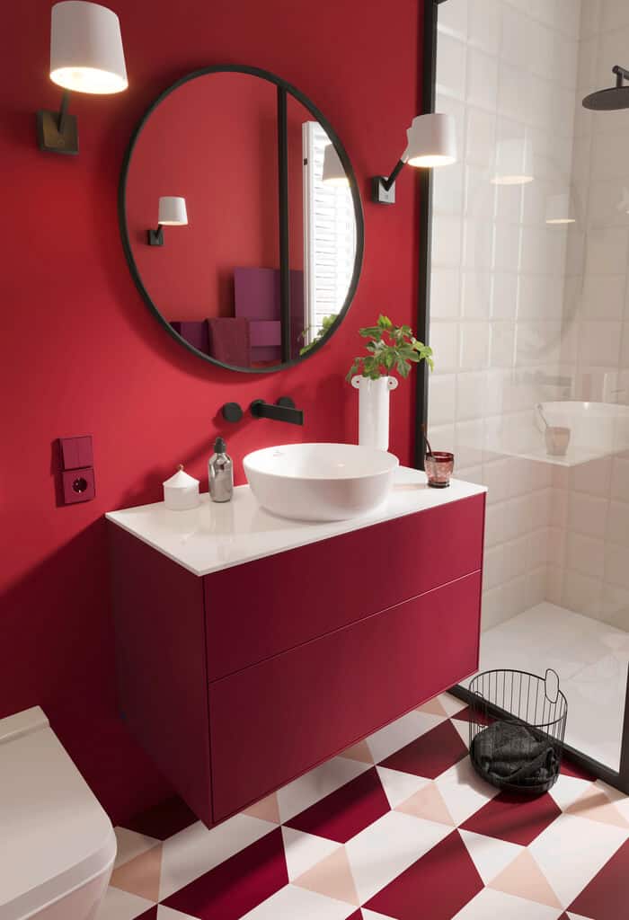 red coloured modern bathroom concept by by Villeroy & Boch featuring white round washbasin, vanity in matte finish, round wall mirror with emotion lighting feature