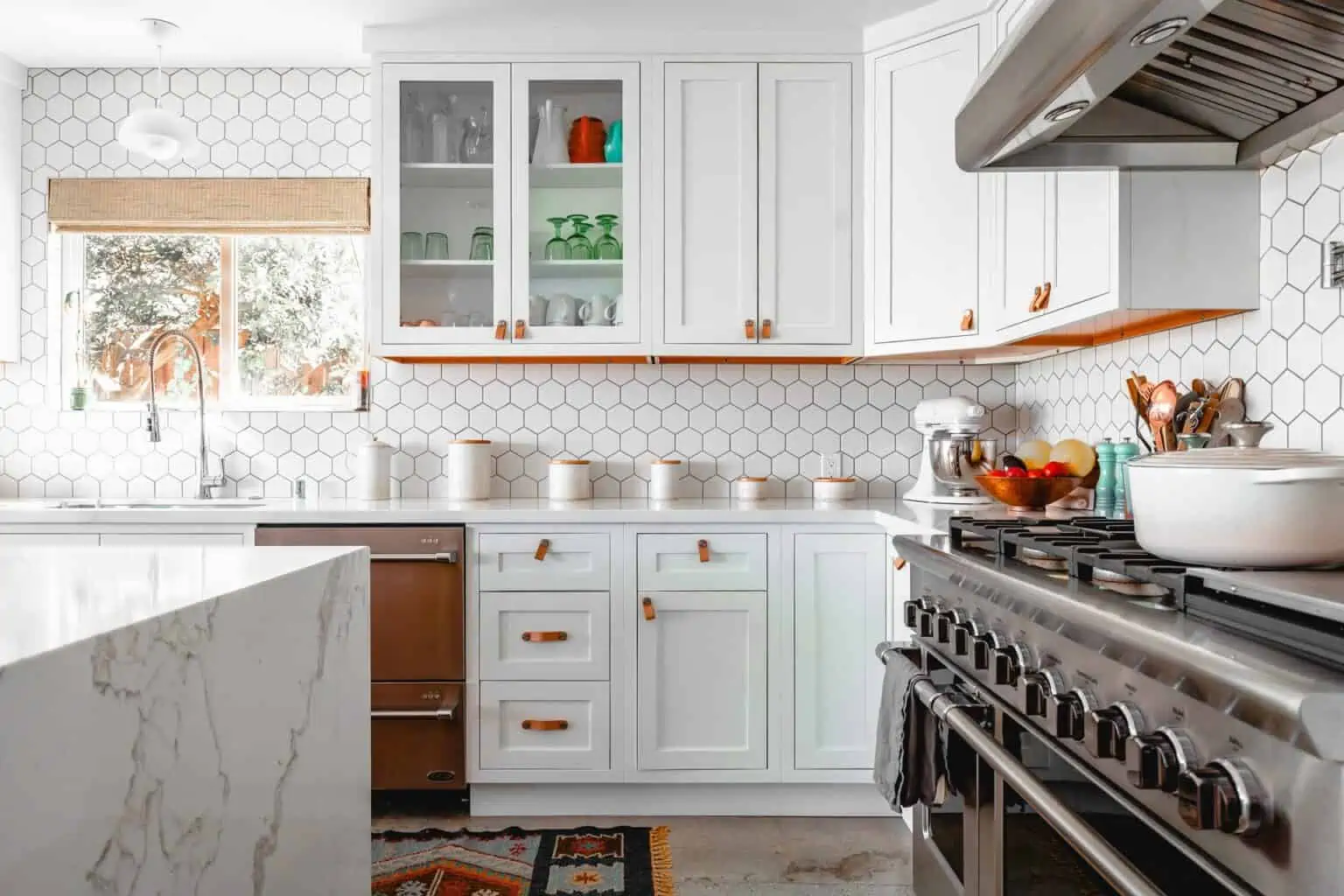 A pretty white-colored wall kitchen cabinet in a white-tiled kitchen.