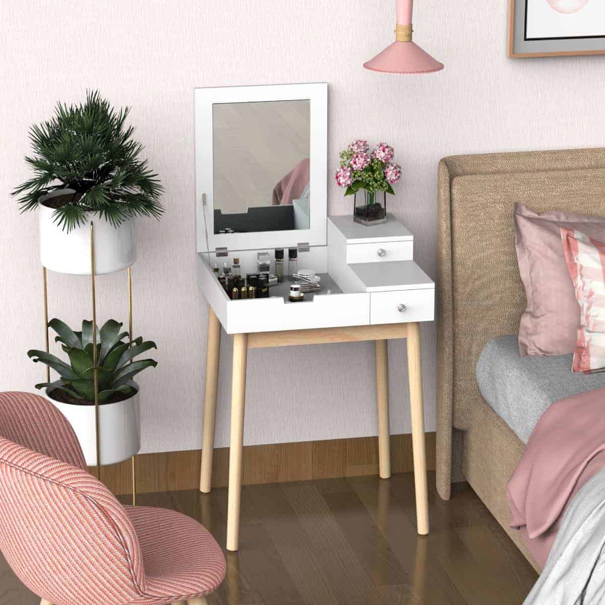 A really cute and compact dressing table design with a rectangular mirror and little storage space, kept in a pink-themed bedroom.