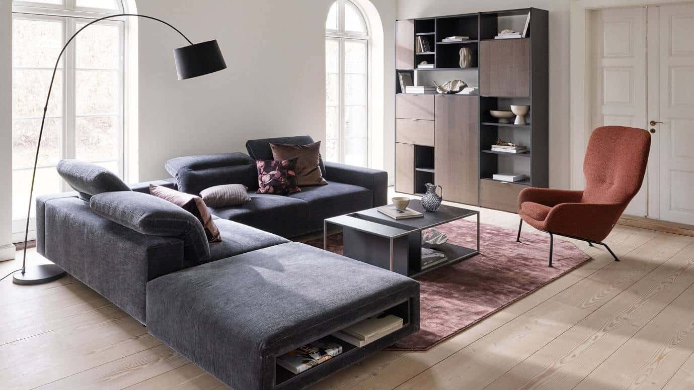 a living room with black couch and a brown cupboard