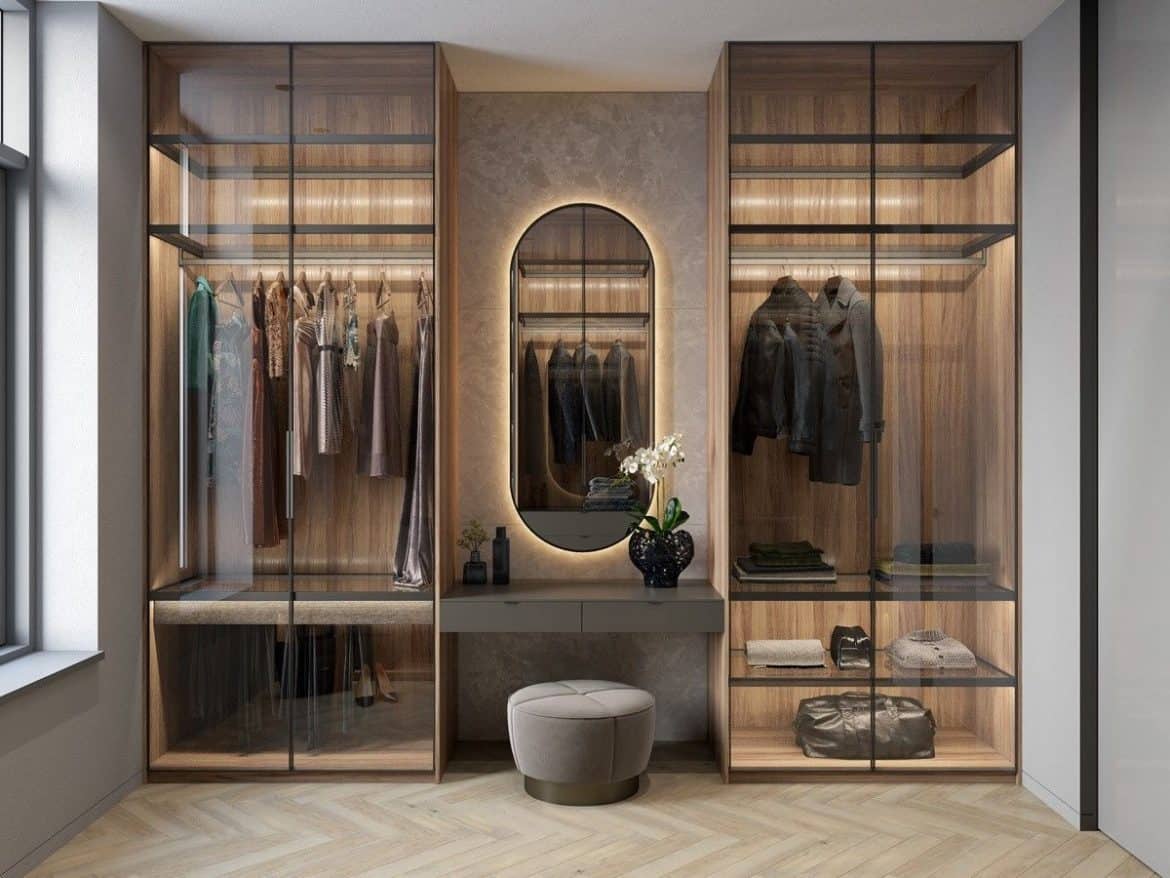 closet with glass doors, beige rug, clothes and seating arrangement