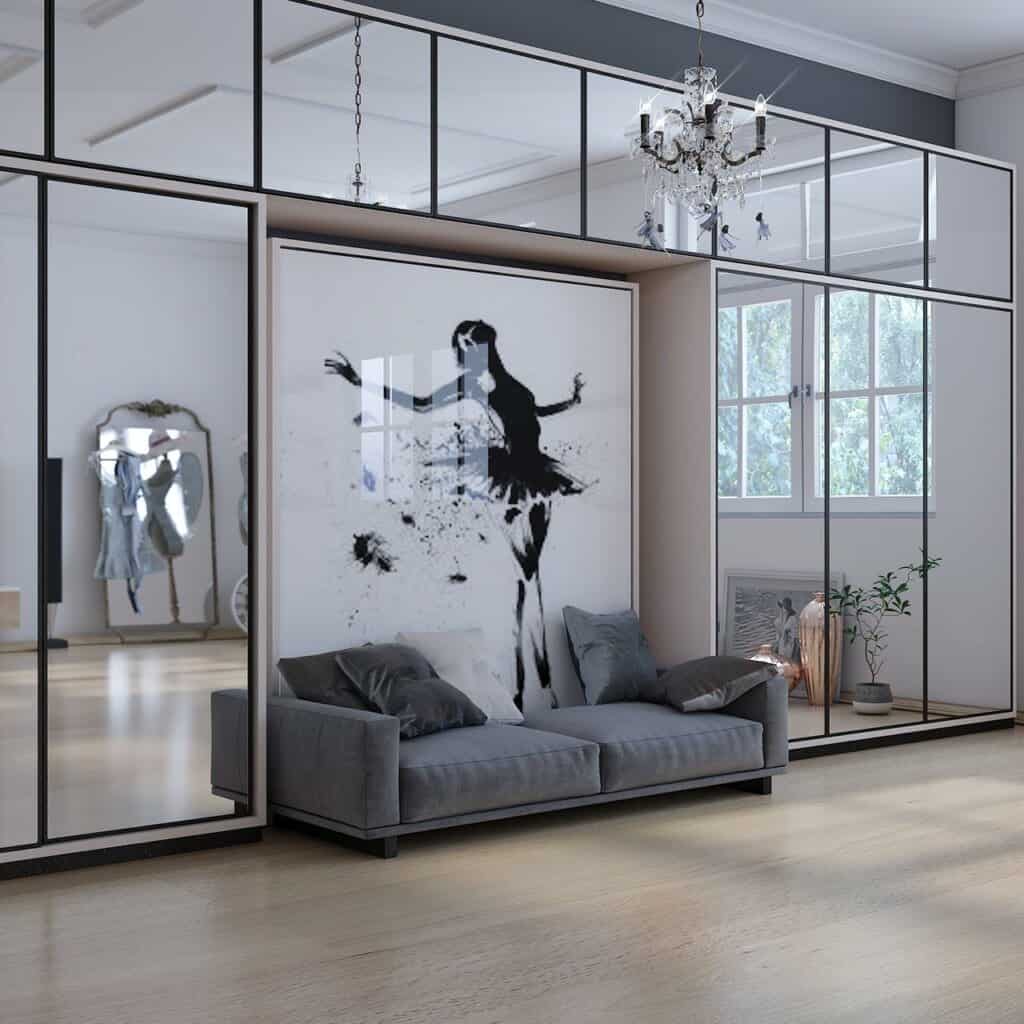 a closet with mirrors and a wall painting in black and white with a grey sofa