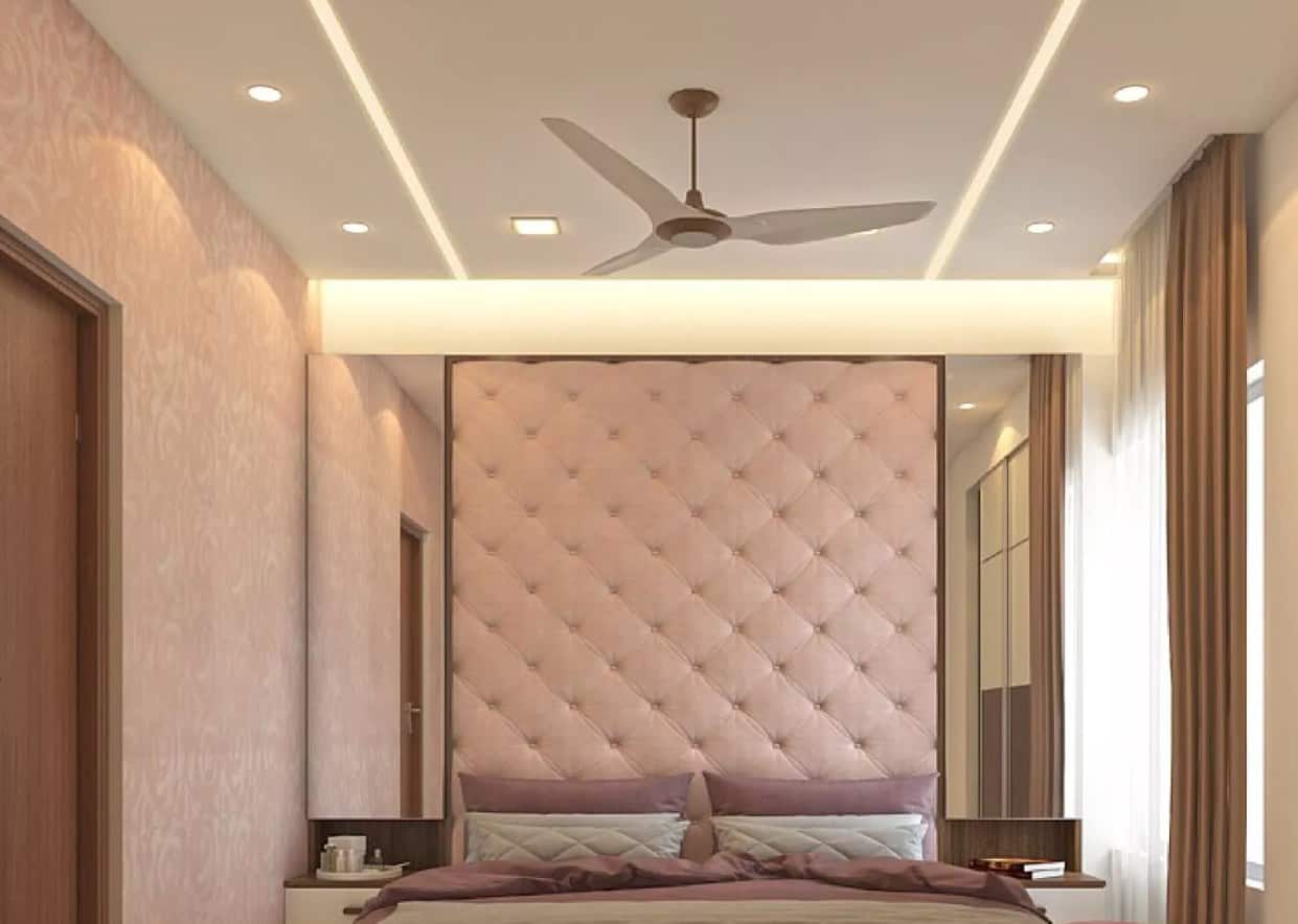 bedroom with pastel pink walls, bed, fan and mirrors