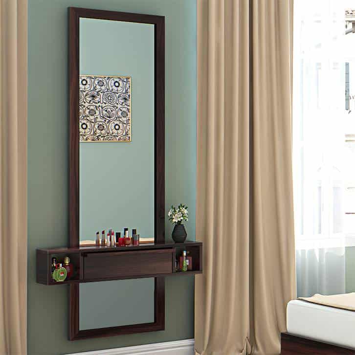 A simple wall-mounted wooden dressing table with a rectangular mirror and minimum storage space, in a green room.