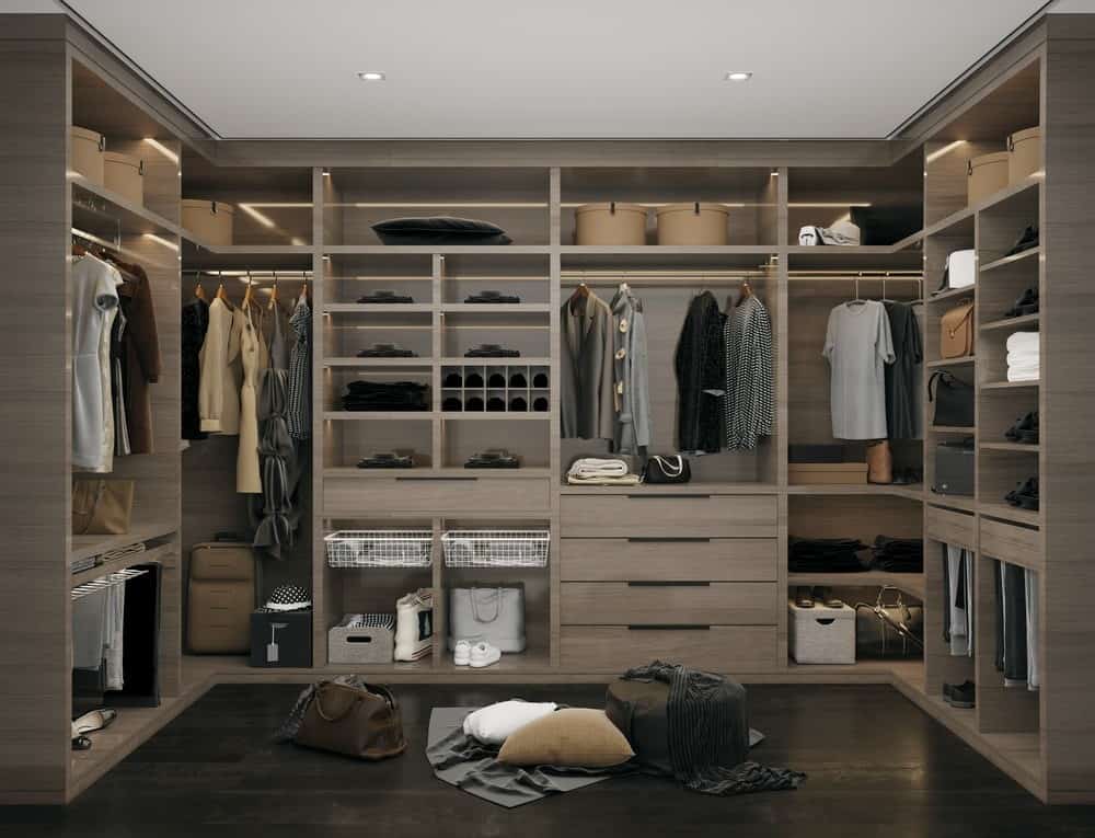 a brown wooden closet with clothes and bags