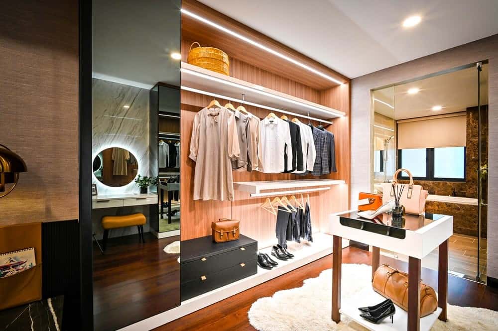 a brown wooden closet with clothes