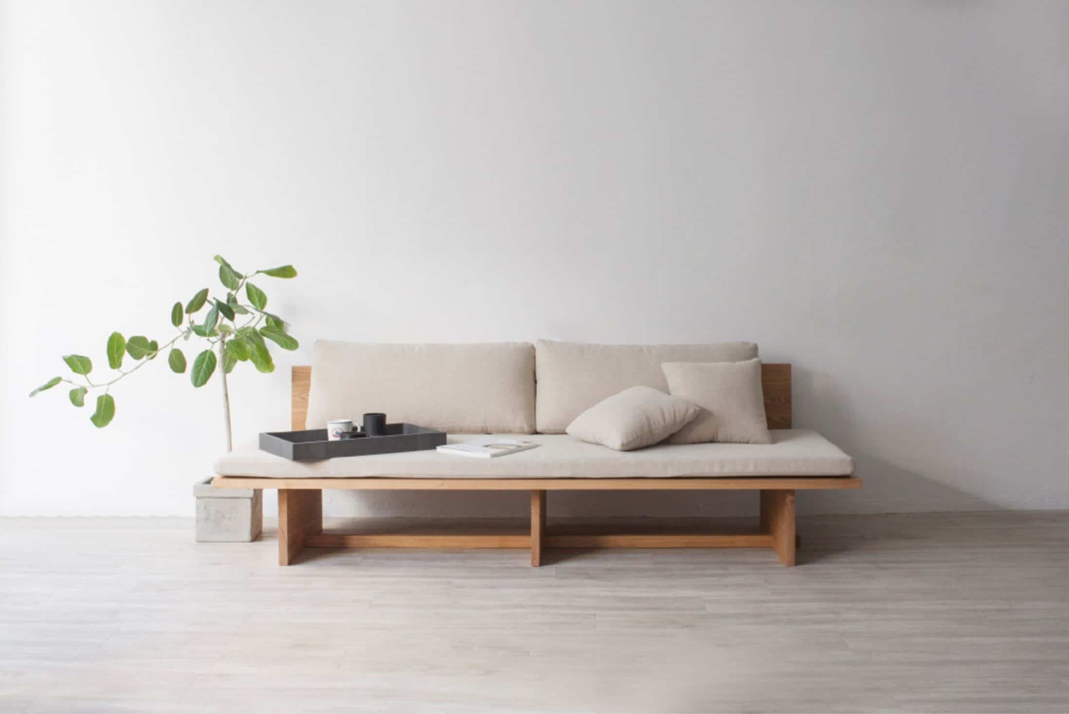 white walls and a wooden sofa with a plant