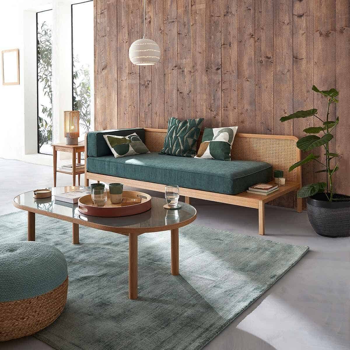 brown walls in a living room with green rug and wooden sofa