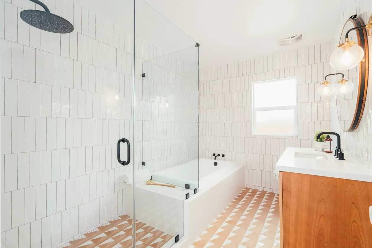 White drop in acrylic tub in a bathroom with orange tiles