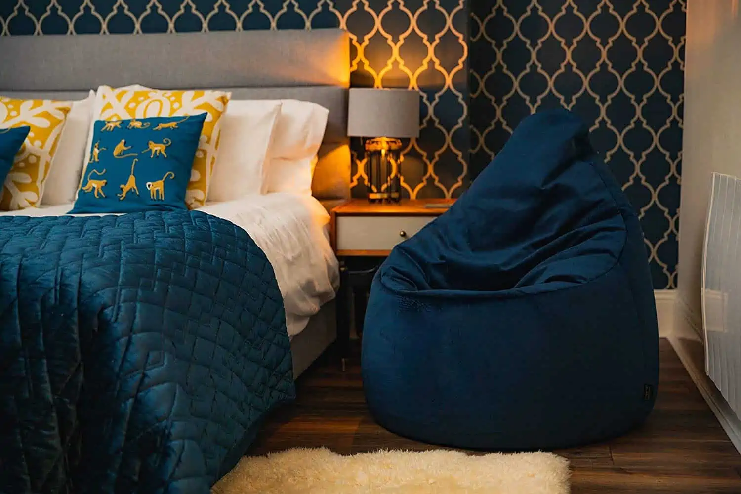 blue bean bag chair in this cosy bedroom with morrocan wallpaper