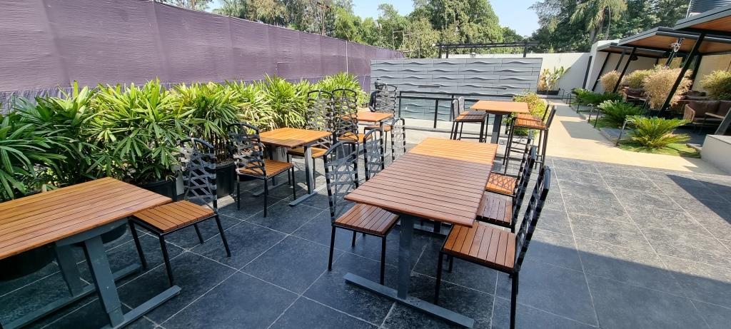 outdoor seating at restaurant, brown wooden garden furniture, dining chairs and tables