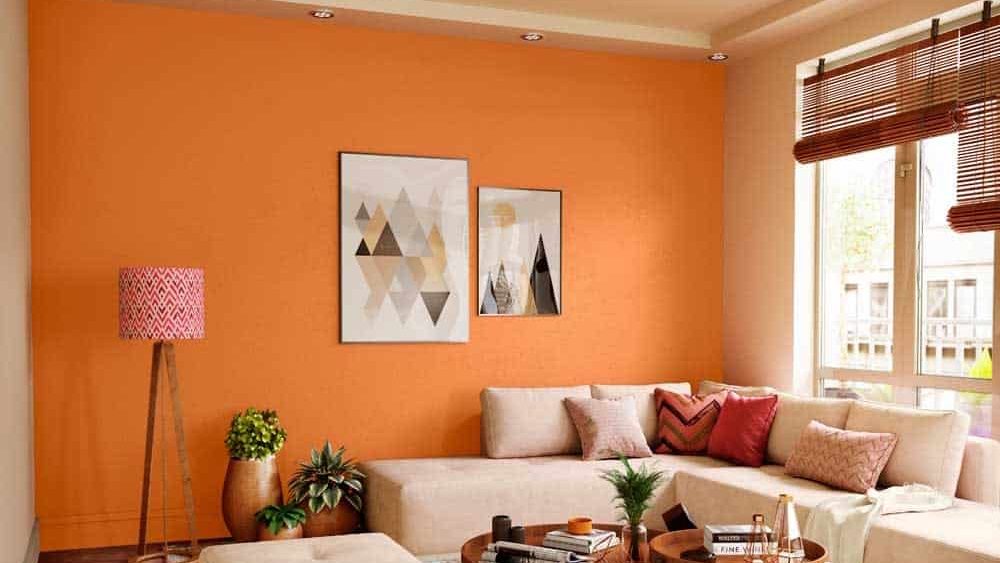 orange living room with beige sofa, table, plant