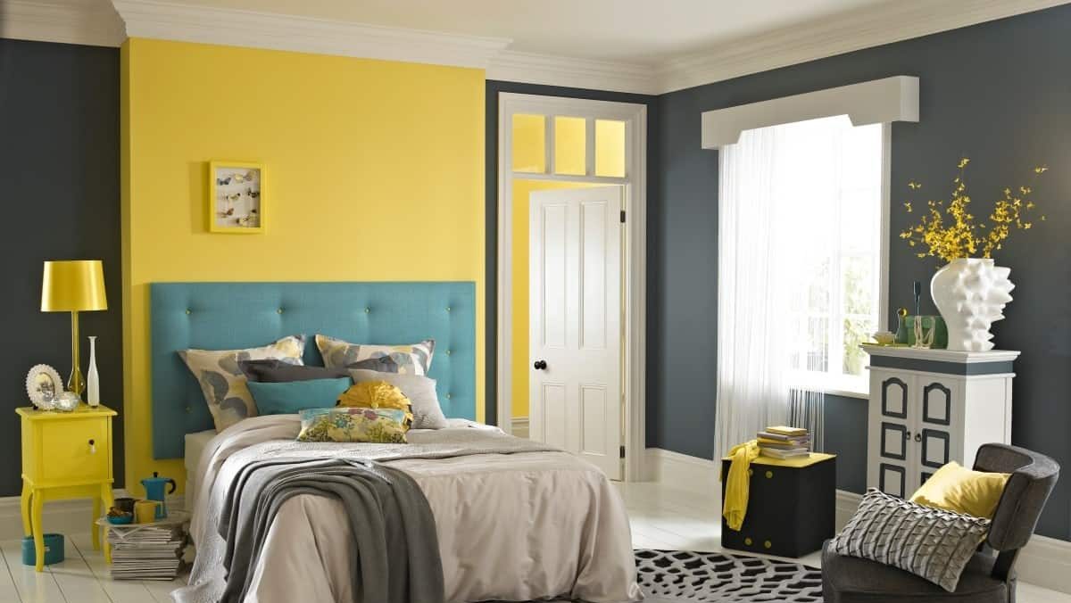 yellow and blue bedroom, bed, rug, chair, table