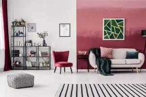 color coded wall with white sofa, red chair, rug and a shelf