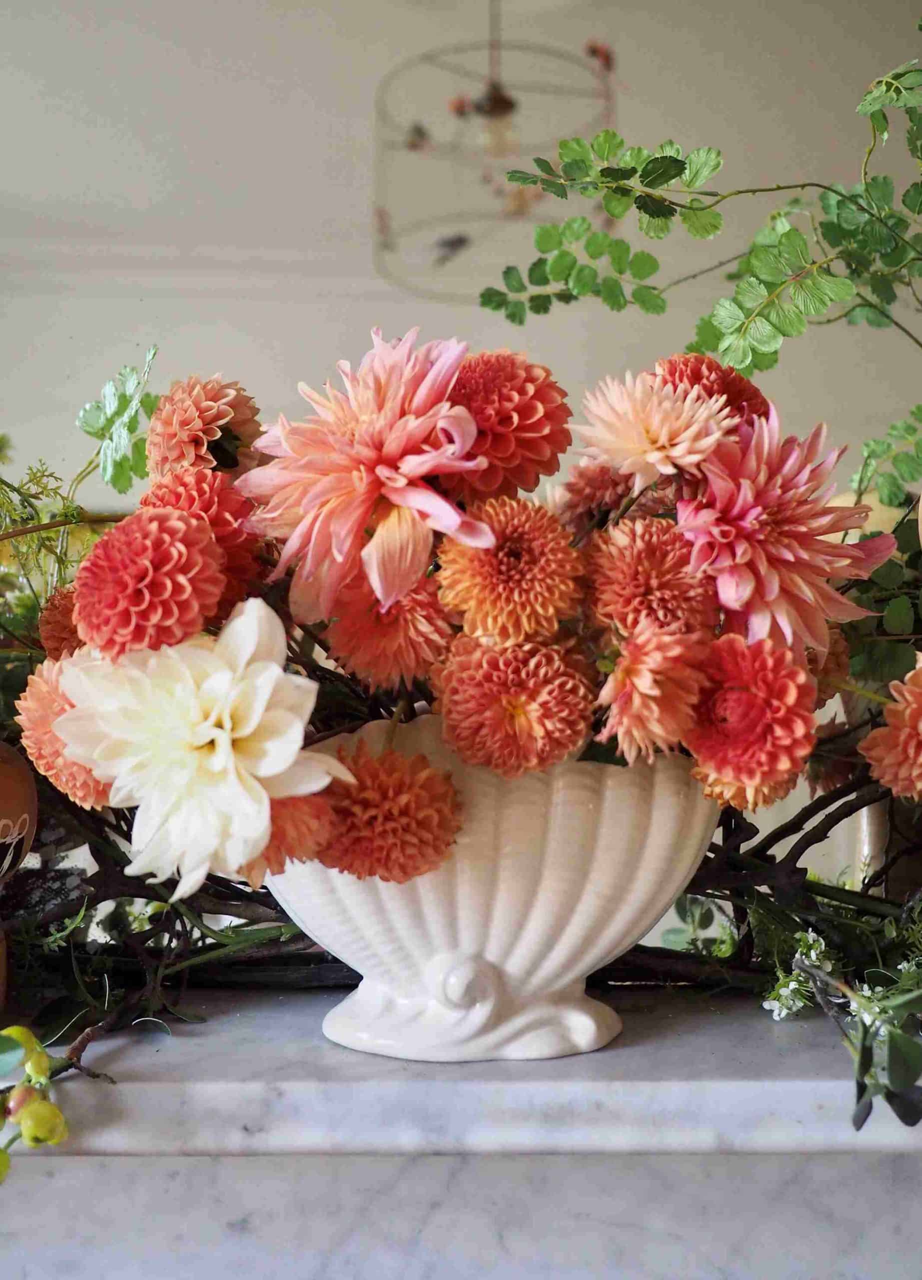 orange and white flowers in a white pot