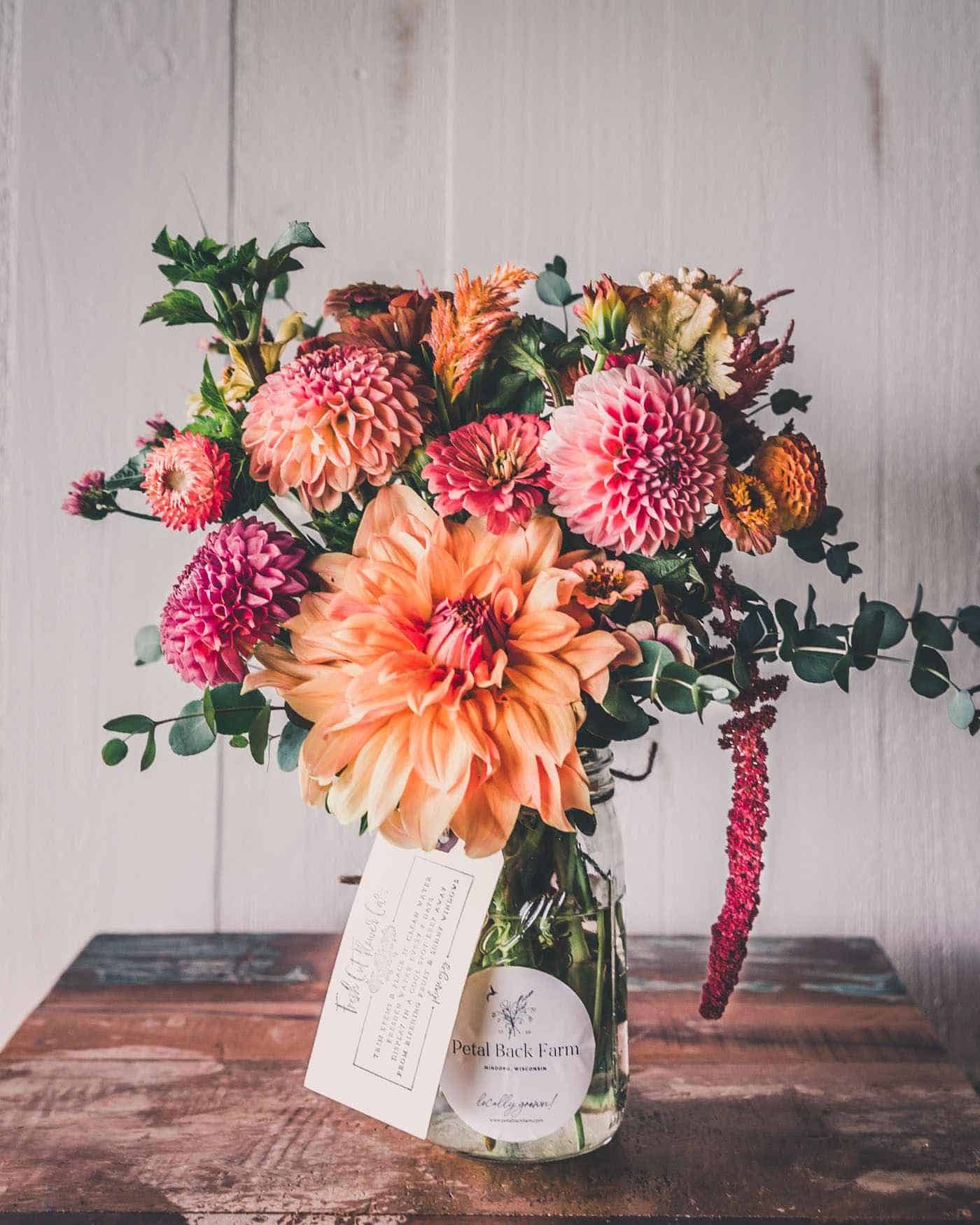 orange and pink flowers in a pot on a table