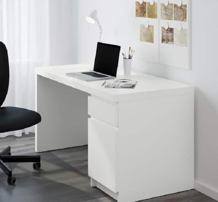 white desk in melamine finish with white walls and black chair