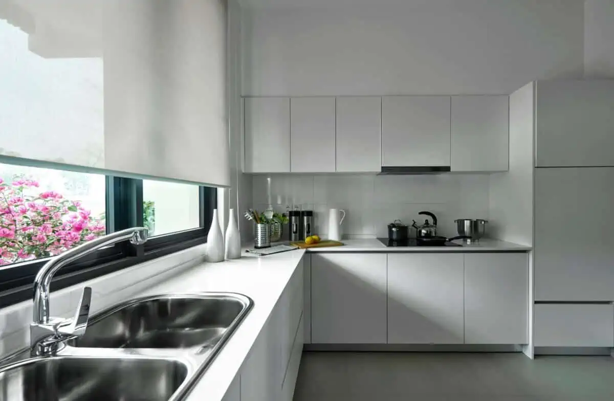 A modern kitchen with wall tiles and properly placed sink.