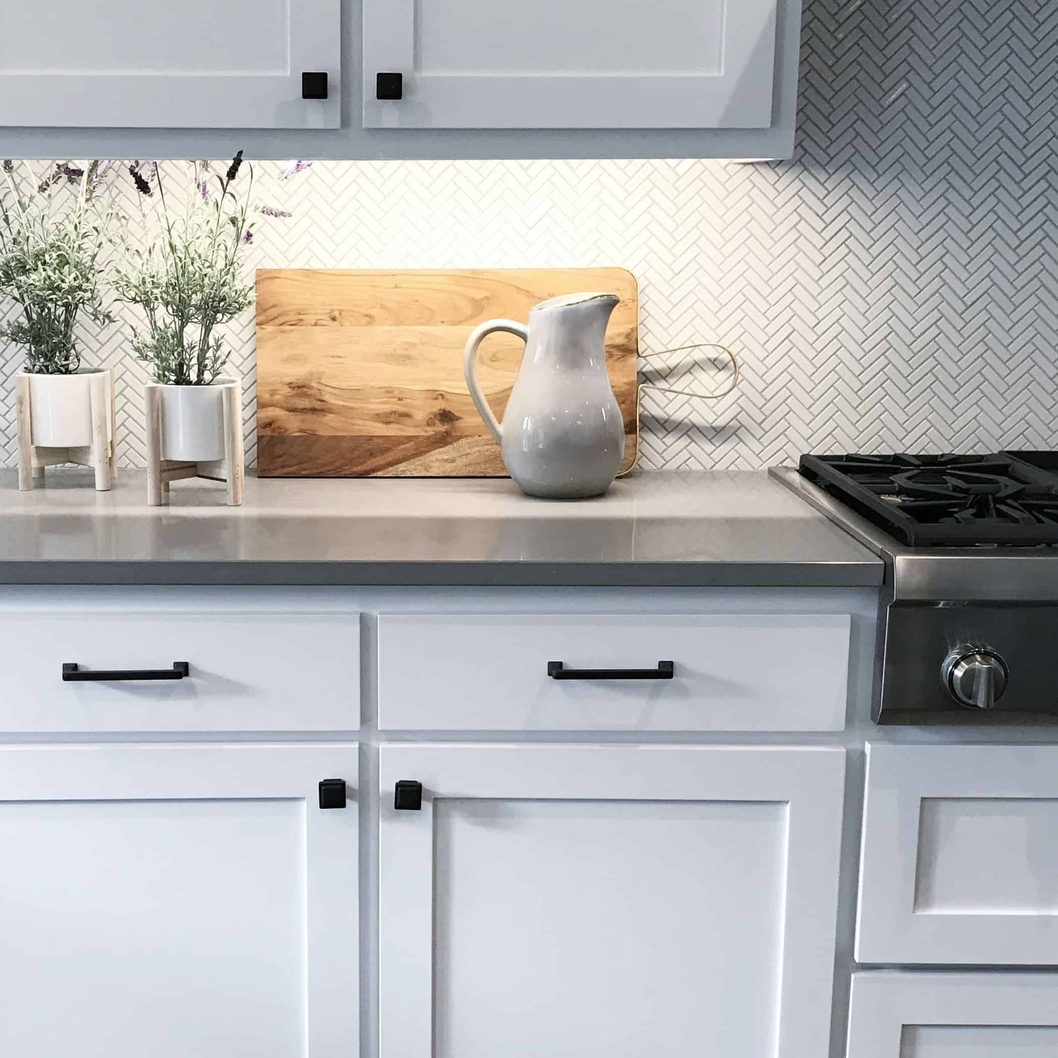 white kitchen cabinets and drawers with matte black hardware, drawers with pull handles and cabinets with knobs