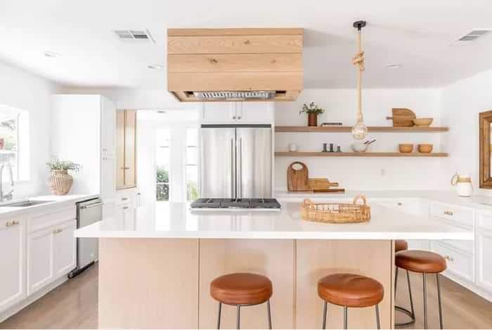 Big white spacious kitchen with seating island and stools