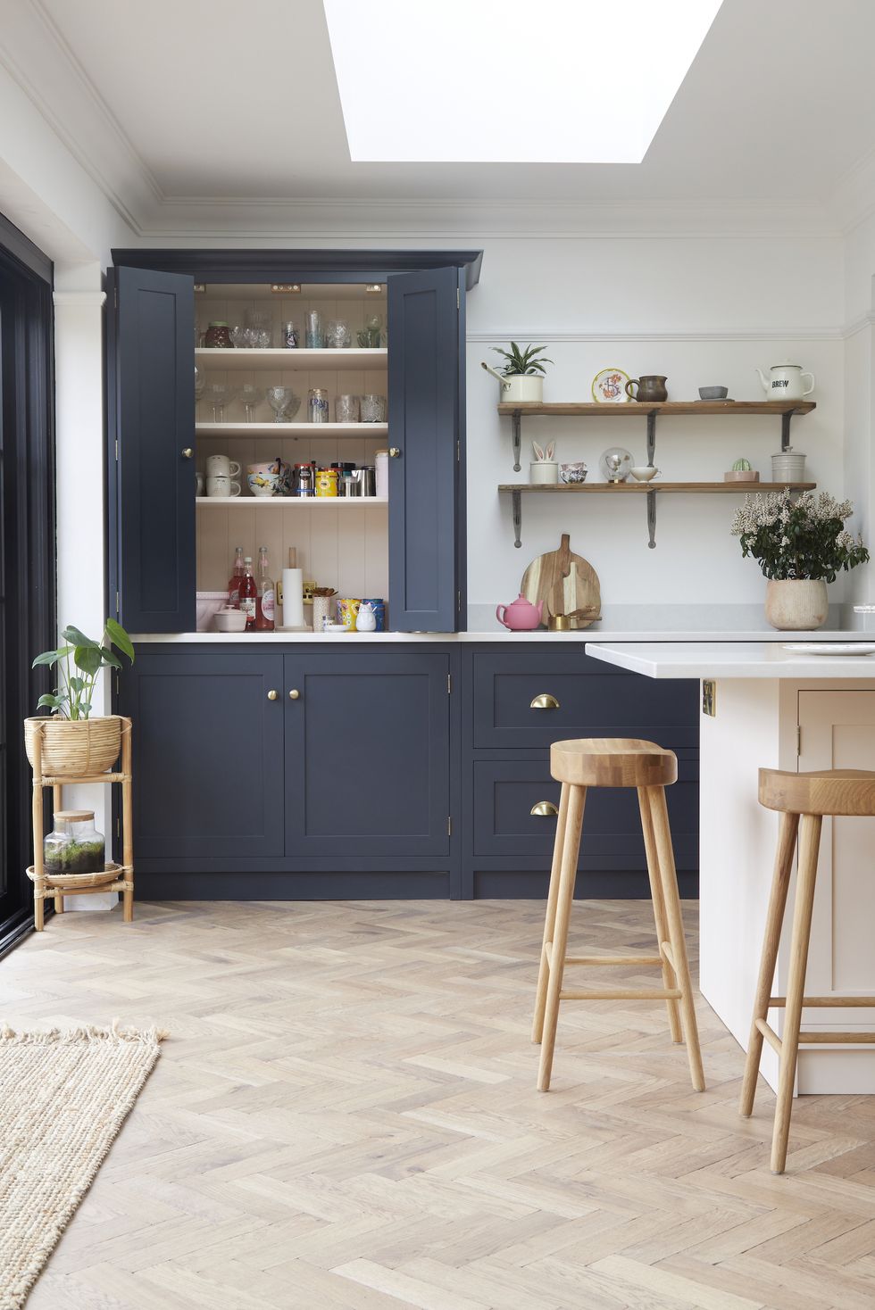 blue wardrobe in a kitchen with wooden flooring, kitchen island and chairs