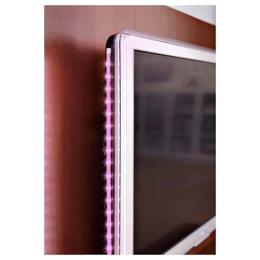 A pink LED strip lighting encircling a television.