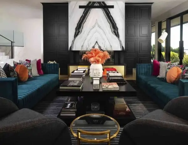 modern home decor idea for a dark themed living room with black accent wall, blue sofa, black centre table, colourful throw cushions