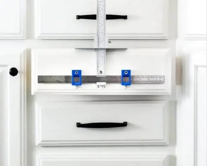 readjust cabinet handles by using measuring tape and spirit level