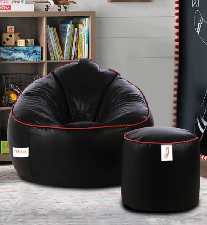 Giant black filled bean bag with pouffe and pink piping