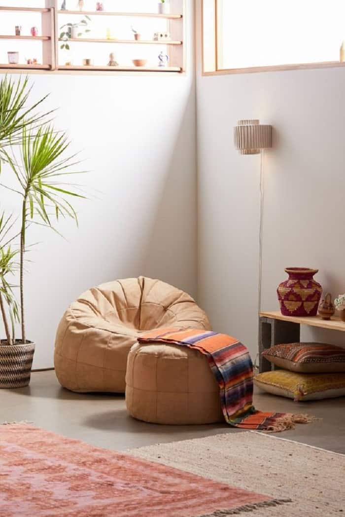 light brown beanbag with ottoman and colourful throw and large indoor plants