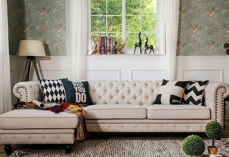 beige tufted couch with carpet and black and white cushions