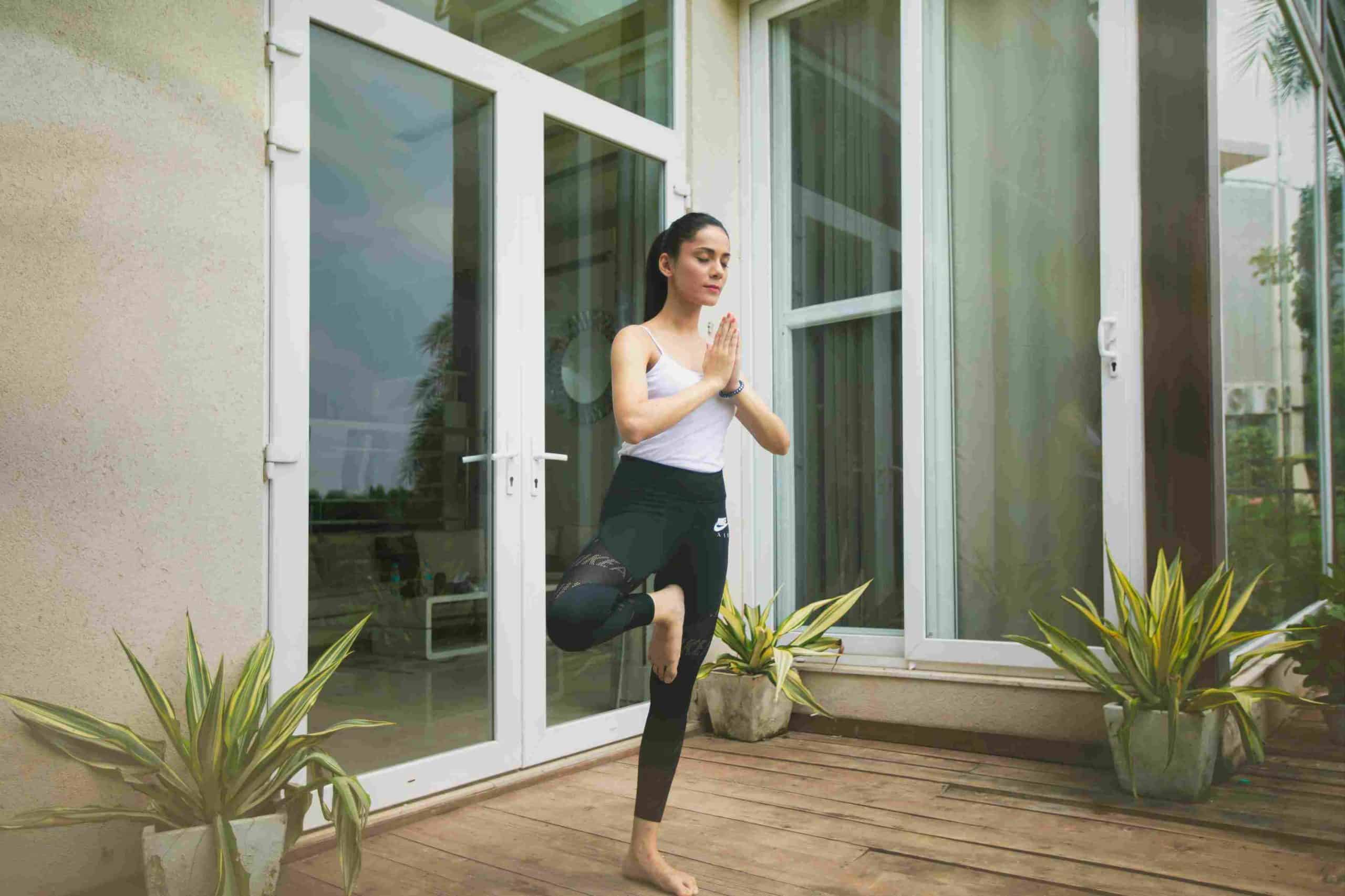 a girl performing yoga outside her upvc doors and windows