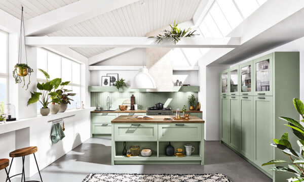 german modular kitchen design with indoor plants, white backsplash, mint green cabinetry and island, and wooden countertops