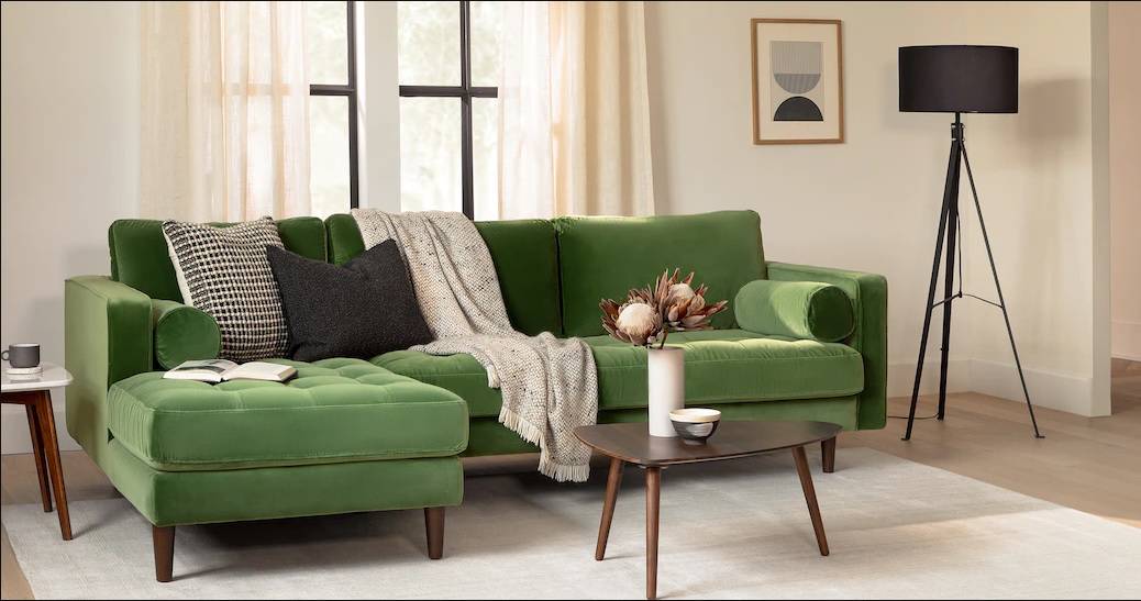 green velvet sofa with a throw and wood centre table