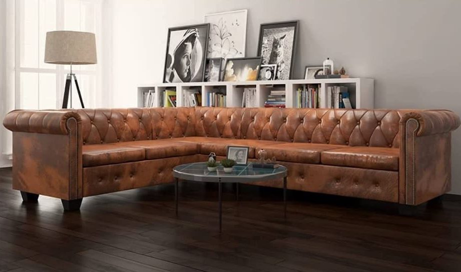 brown leather couch in modern setting with paintings on the wallh